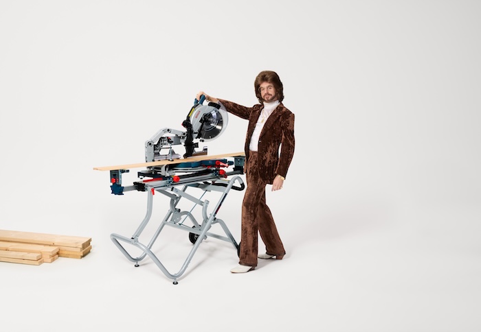 The Bosch 18V Glide Miter Saw displayed prominently with a builder in safety gear